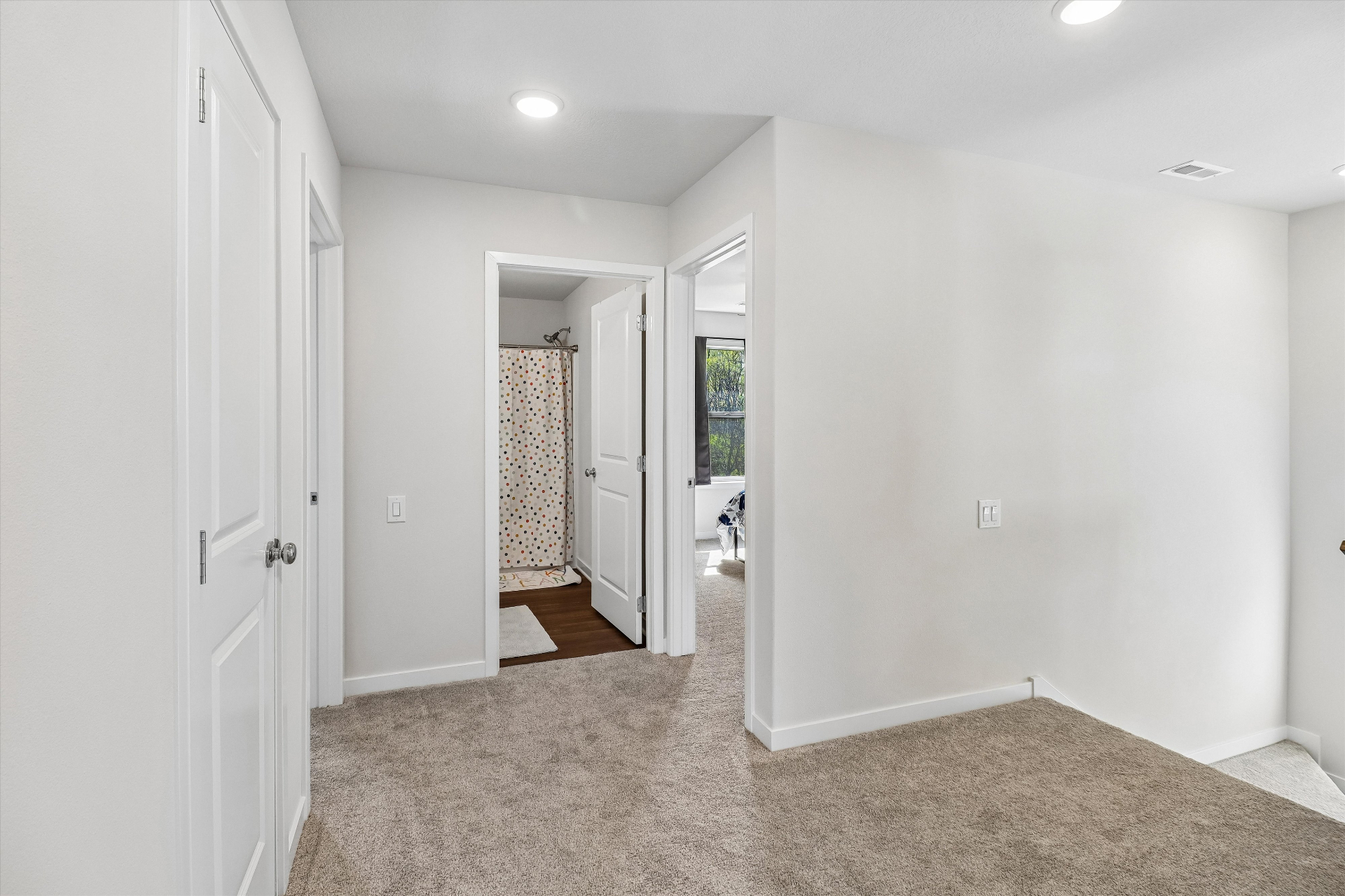 Upstairs landing with bedrooms, full bath, and laundry close at hand