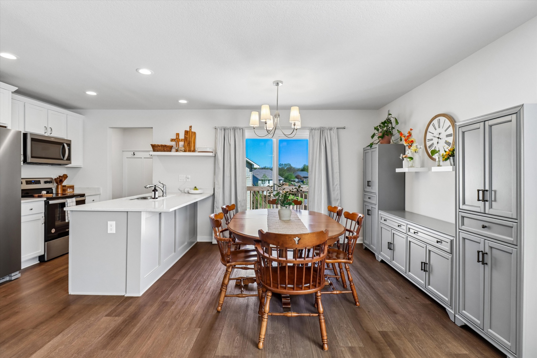 Bright kitchen with quartz countertops, stainless appliances, and slider to the deck