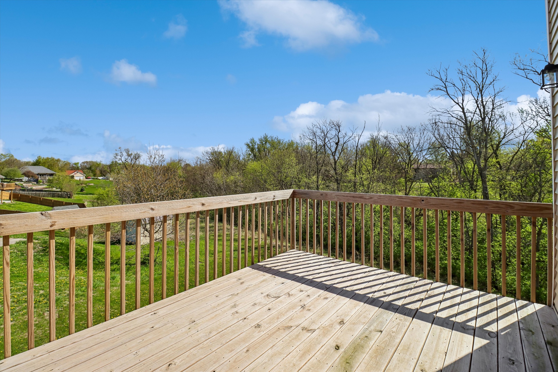 Elevated back deck with treetop and meadow views — no rear neighbors