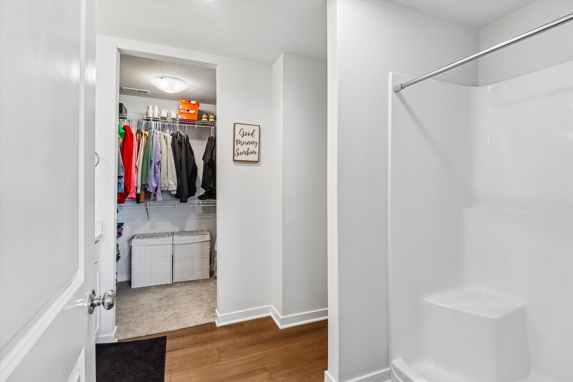 Primary bath entry with oversized walk-in closet and tiled shower