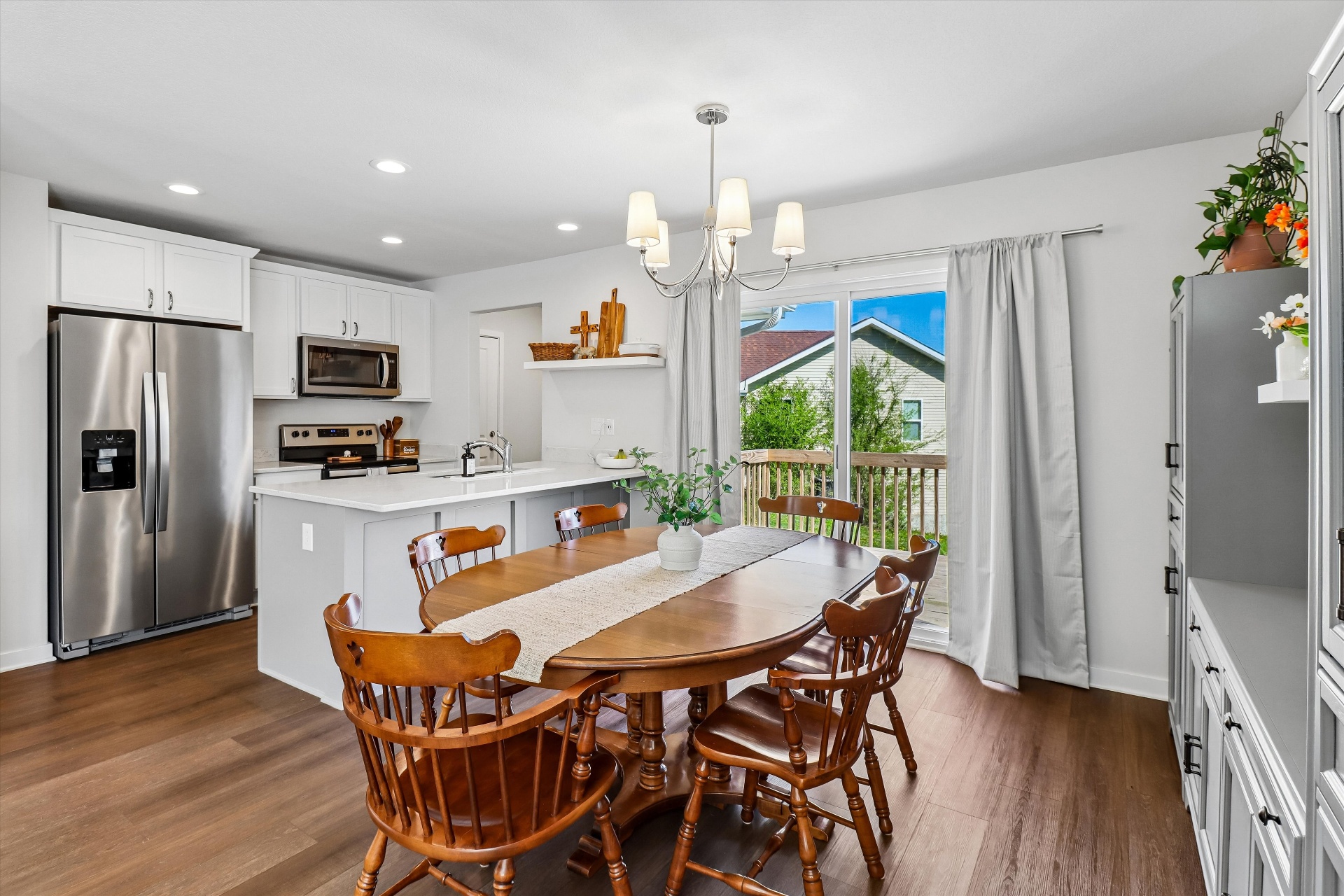 Open kitchen and dining with quartz island and slider to the deck