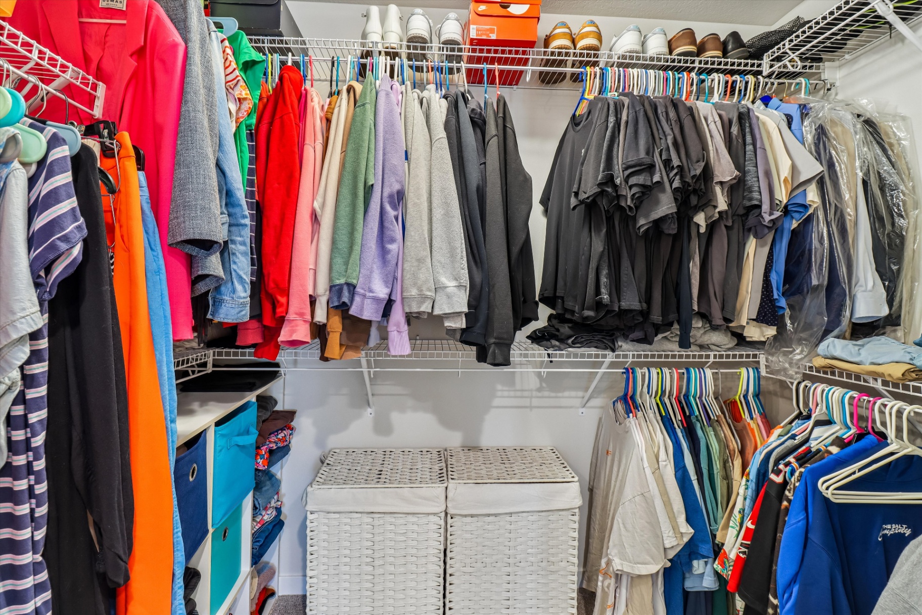 Large walk-in primary closet with extensive hanging and shelf storage